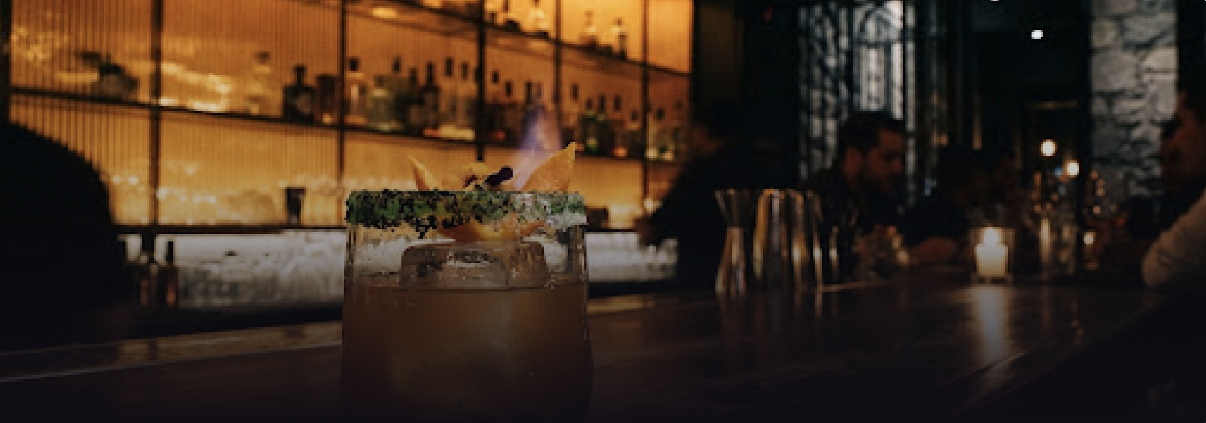 Close up architectural detail of an upscale cocktail lounge bar in CDMX, backlit textured fluted amber glass with polished jade stone cocktail rim